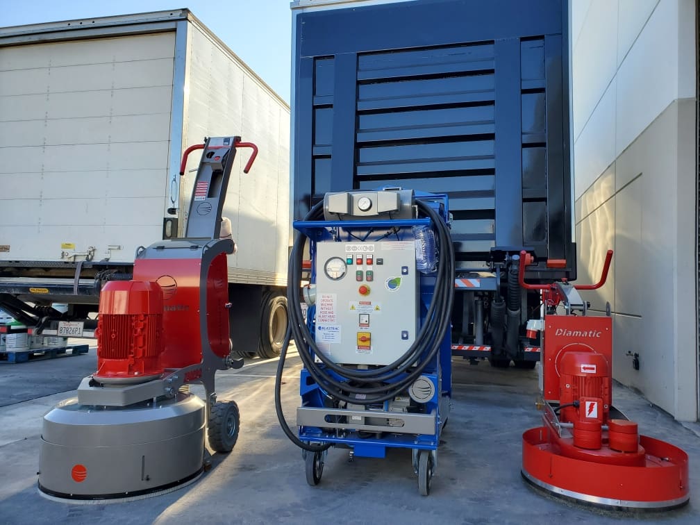 Two industrial floor grinders and a truck.