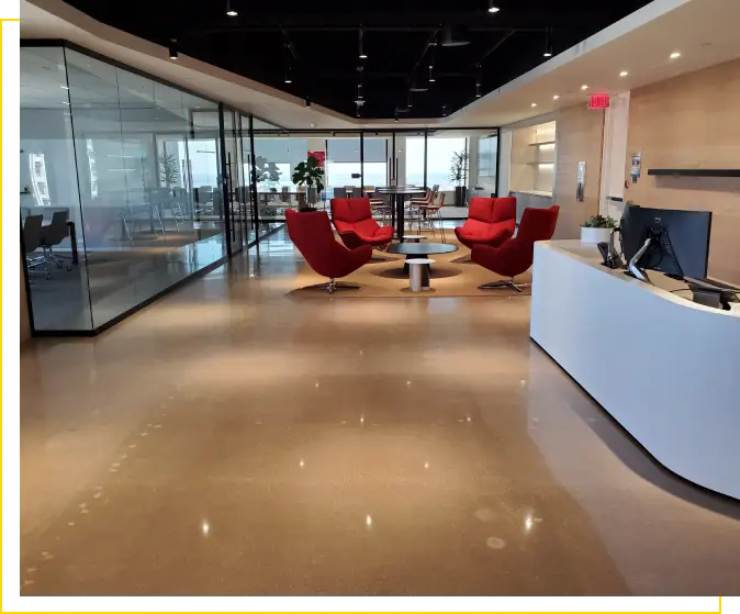 Modern office with red chairs and white desk.